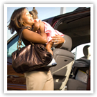 A mother carrying her baby to the car. 